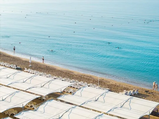 Grand Park Lara Hotel — white beach canopies and loungers on the Lara sand