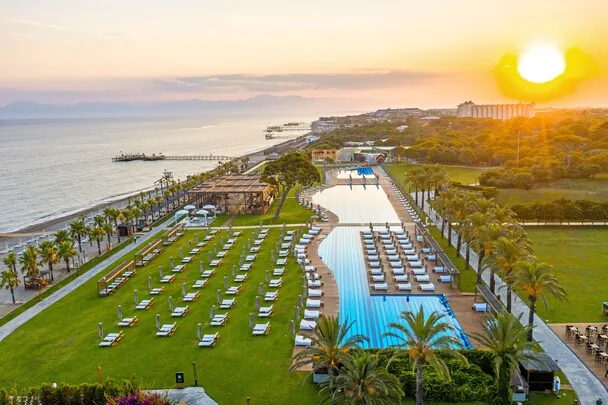 Rixos Premium Belek — beachfront pools and sun loungers at sunset