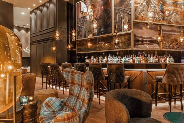 Motel One Glasgow — One Lounge bar with tartan armchair and pendant lights