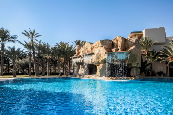 The Russelior Hotel & Spa — pool with rock waterfall and palm trees, Hammamet