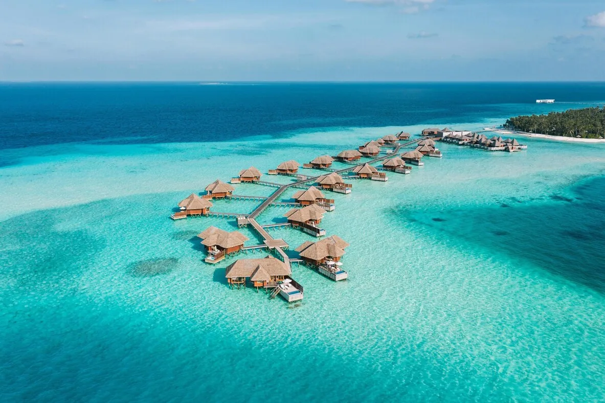 Conrad Maldives Rangali — overwater villa walkway at sunset
