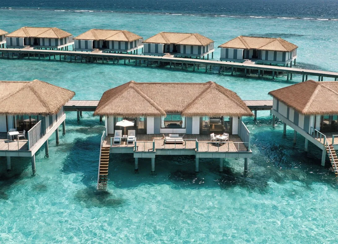 Noku Maldives — beach villa and palm-lined lagoon