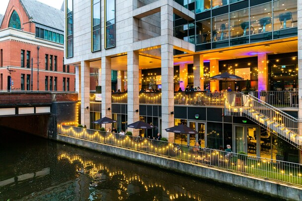 Holiday Inn Manchester City Centre — canal-side terrace with string lights at dusk