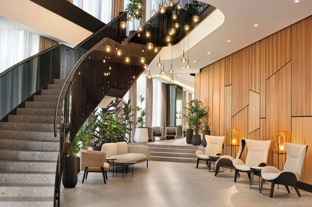 AC Hotel by Marriott Split — modern lobby with curved staircase and globe lighting