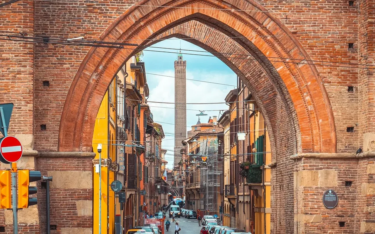 Asinelli Tower framed through a brick arch on Strada Maggiore, Bologna
